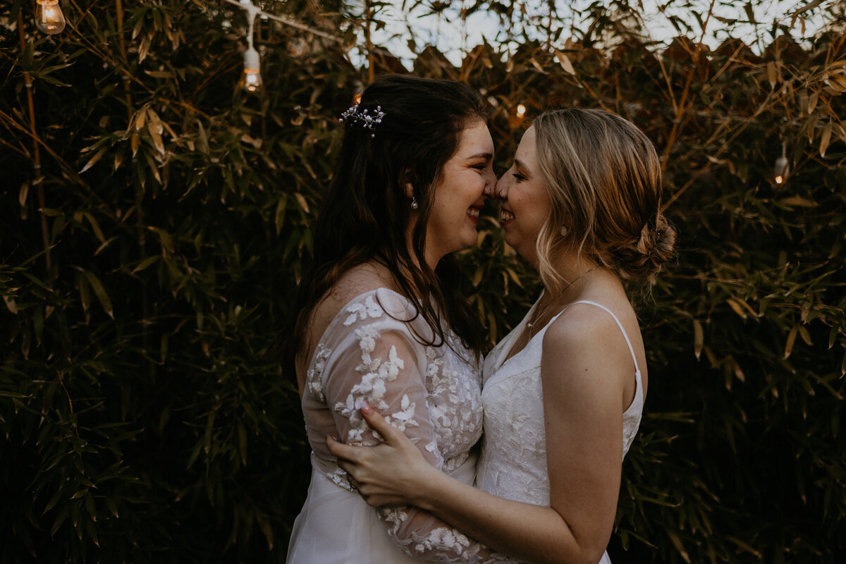 two brides holding each other close and smiling