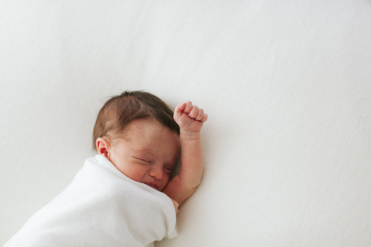 Baby raising his hand during newborn session