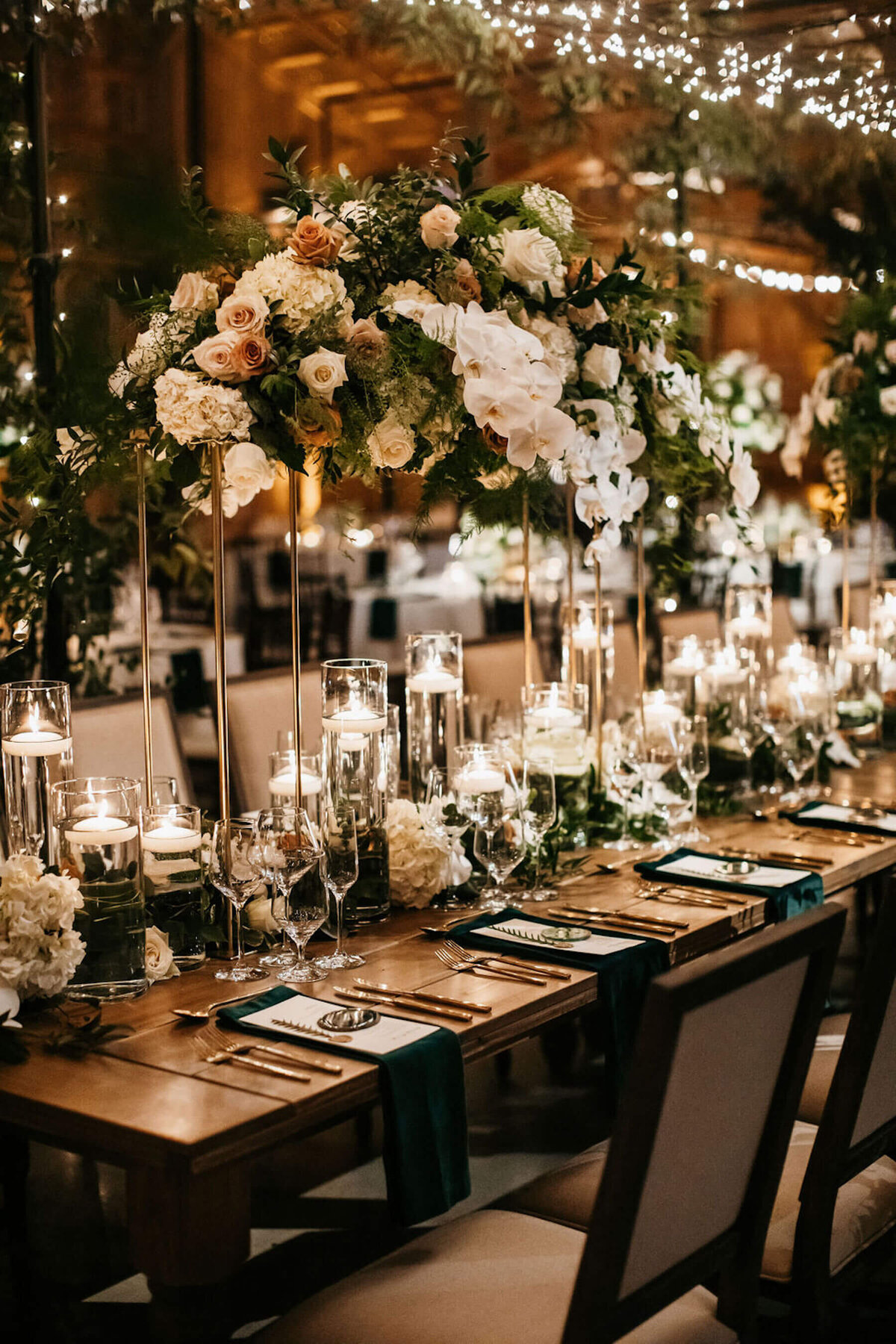 Classy wedding head table with green and white flowers with gold touches