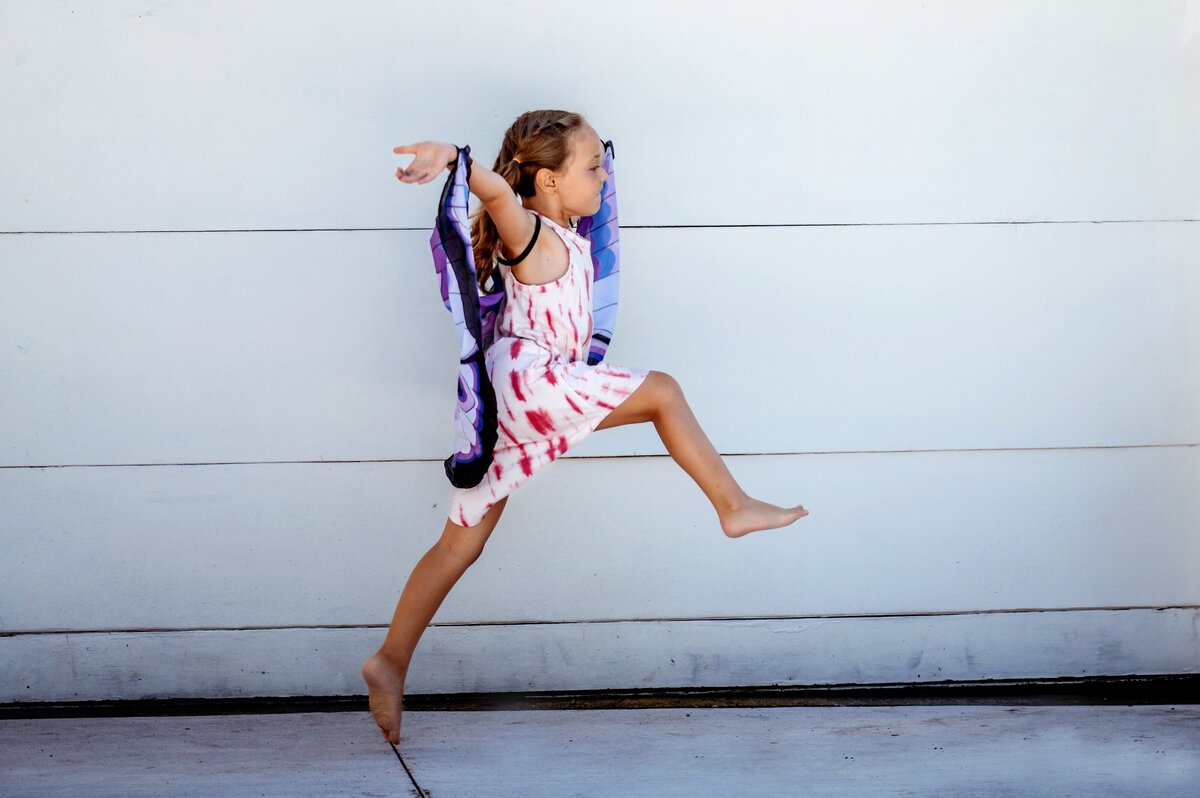 Child in butterfly wings jumping McKennaPattersonPhotography