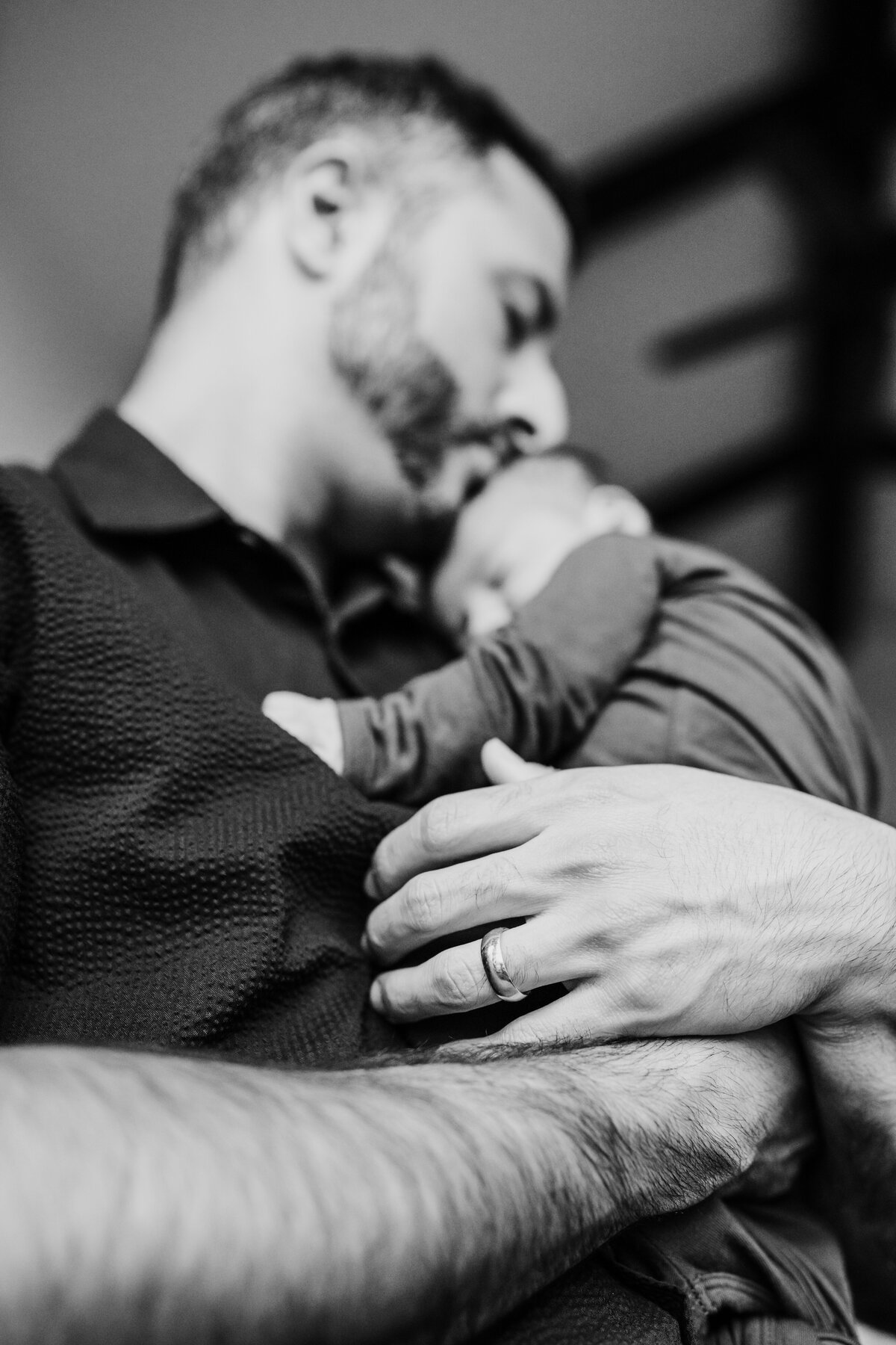 Newborn Photographer, a dad hold his baby to his chest, kissing him