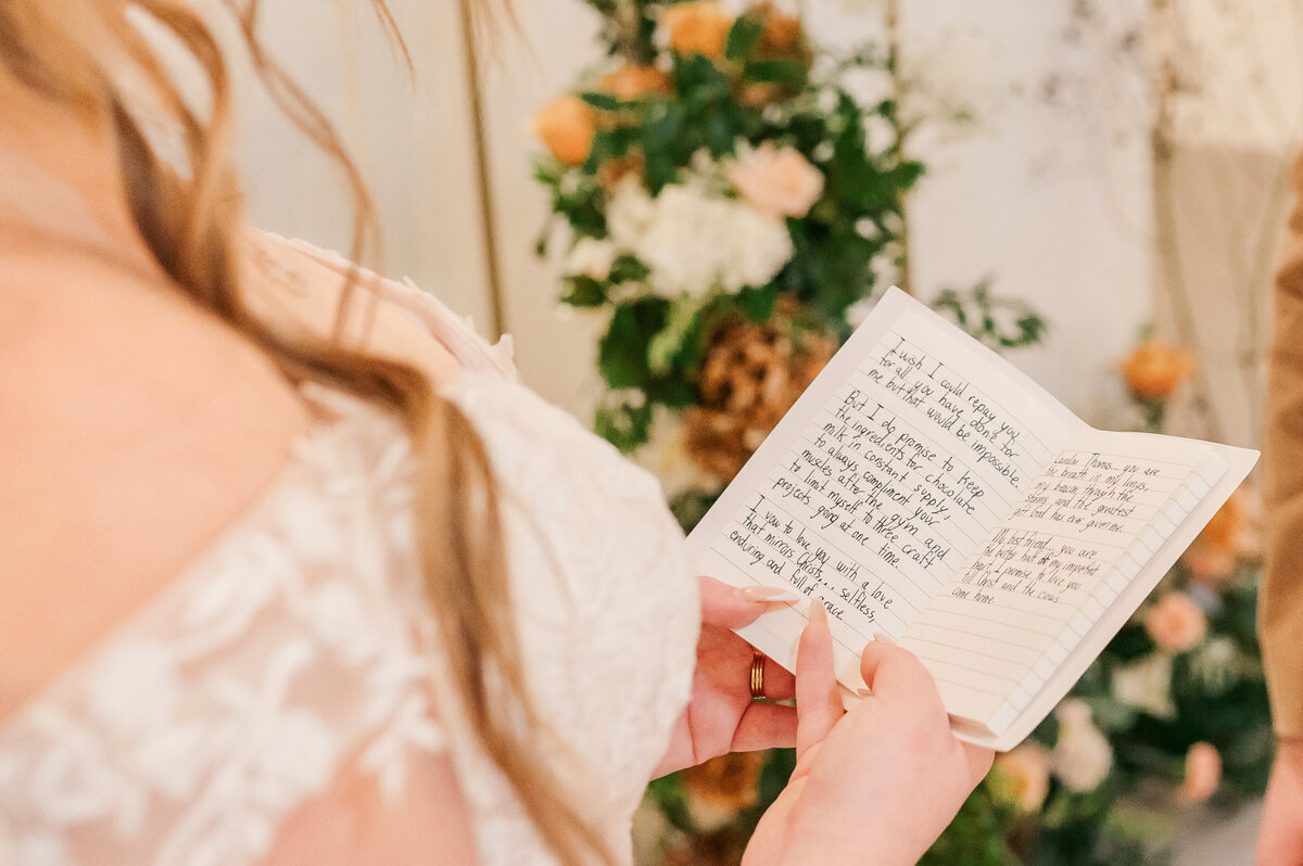 A bride reading her vows to her husband during their wedding ceremony by Raleigh wedding photographer, JoLynn Photography