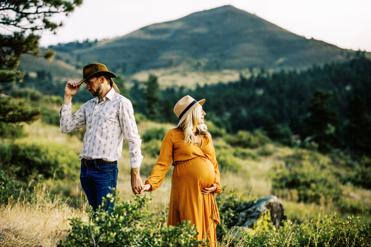 dad and mom hold hands during a lyons colorado maternity photo  session