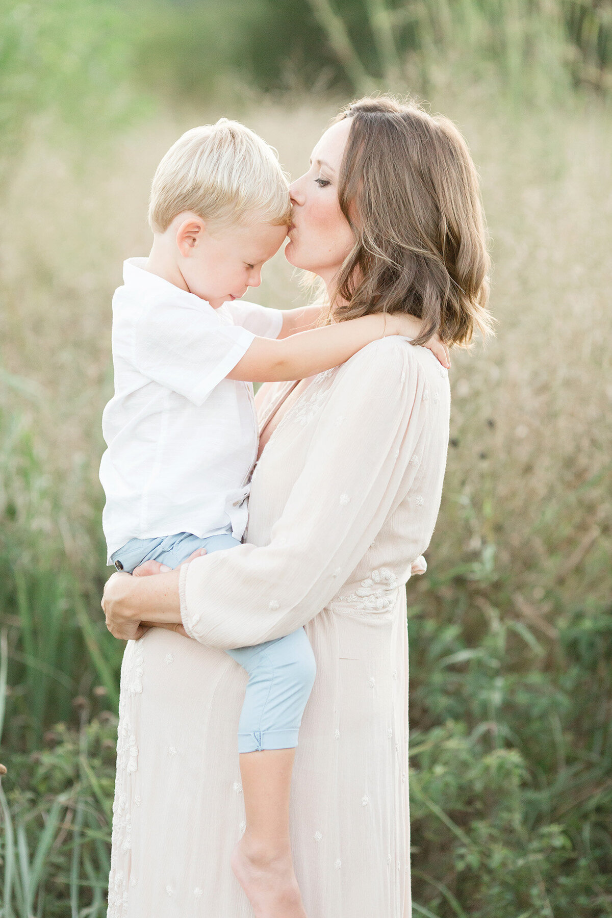 Louisville KY pregnant mother holds her older son during her outdoor maternity photo shoot with Julie Brock Photography