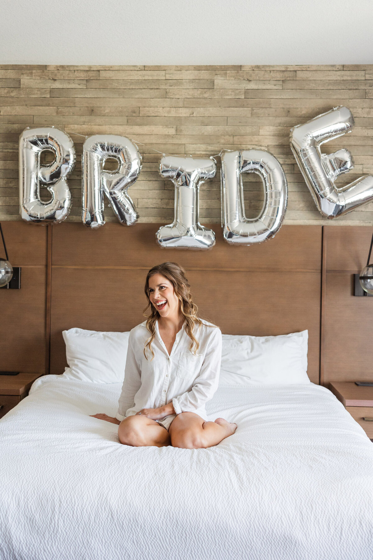 bride sitting on a bed in a robe
