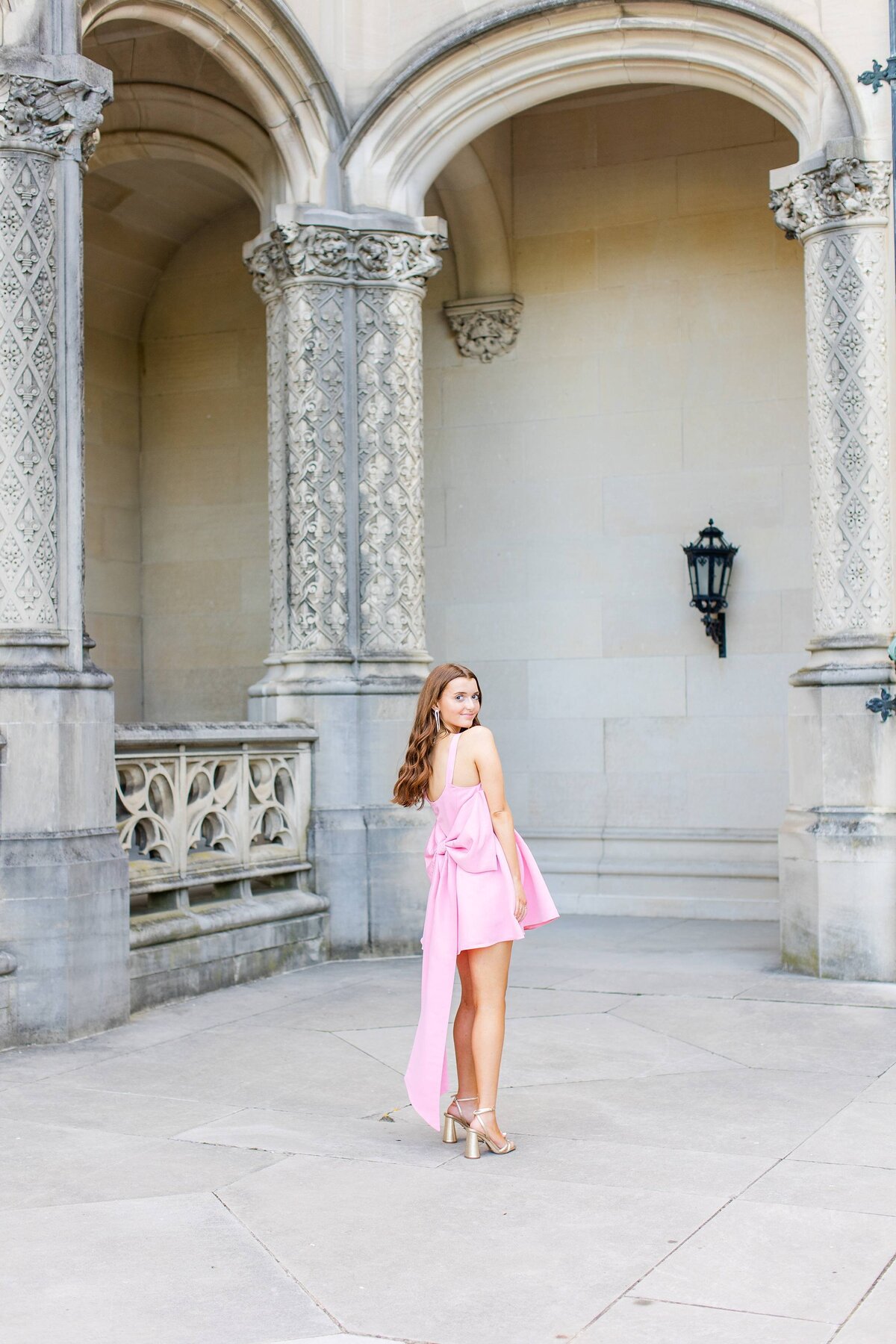 girl with long hair standing in pink dress at biltmore estate