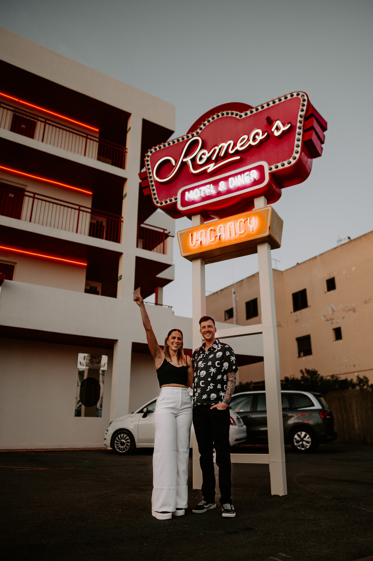 A couple stand under the neon sign at Romeo's Motel and Diner in Ibiza.