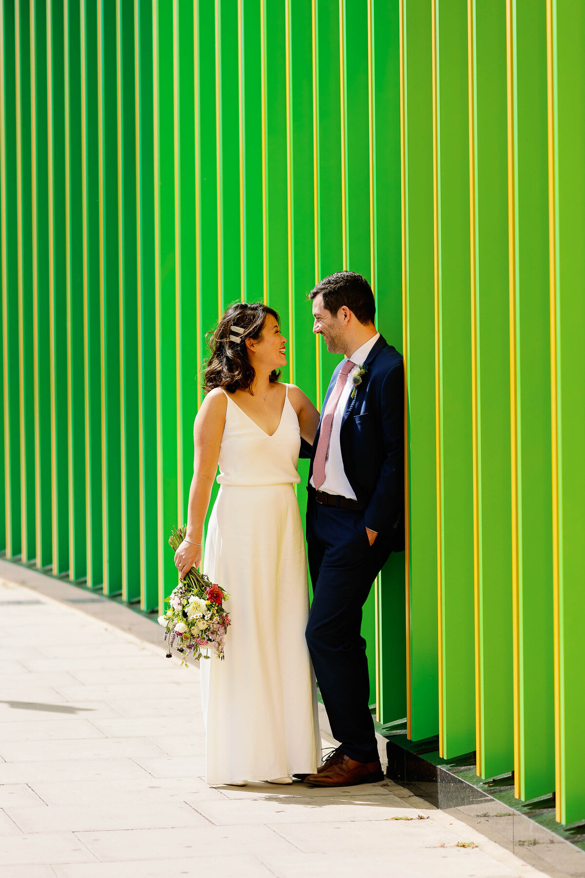 Bride and Groom stood in front of a green backdrop in London