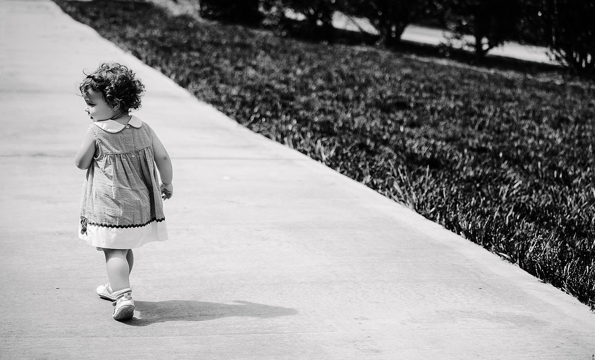 charlotte documentary photographer creates an artistic image of a toddler walking down a road