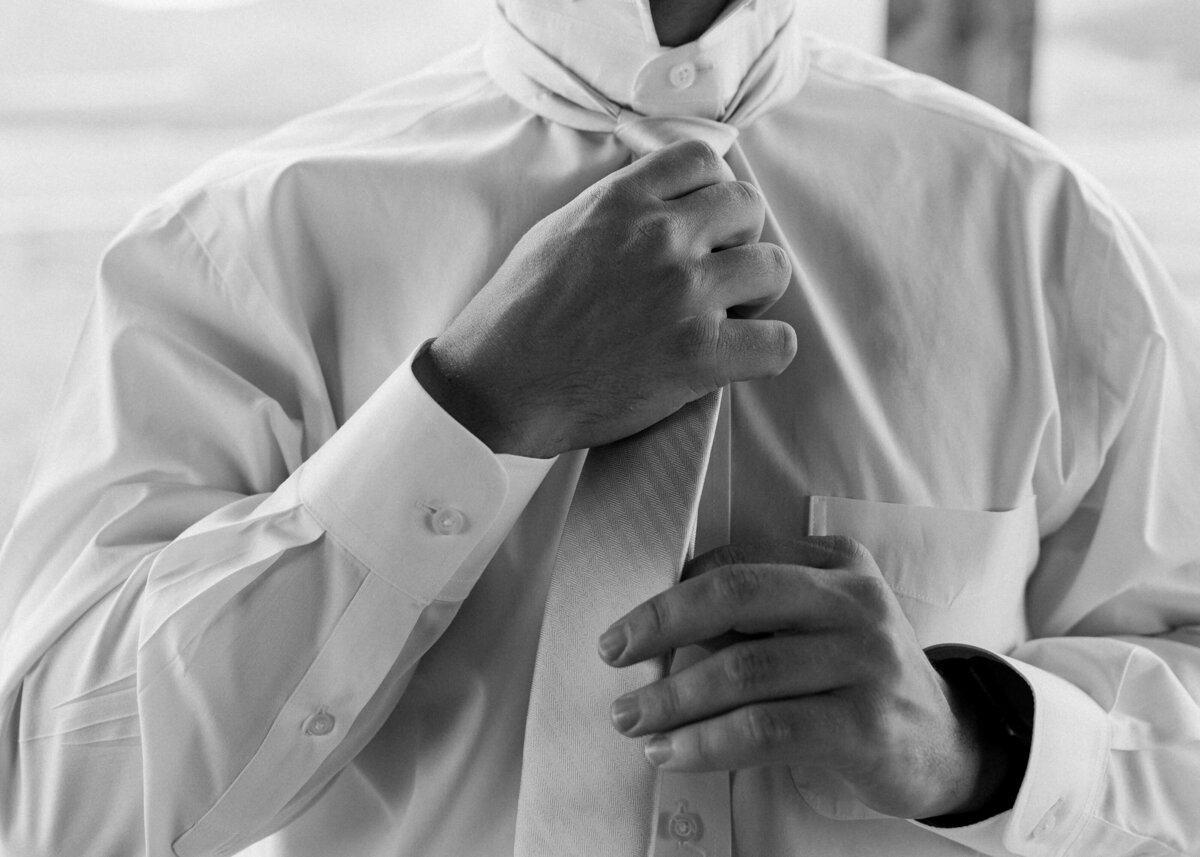 Groom adjusts his tie before getting married to the love of his life