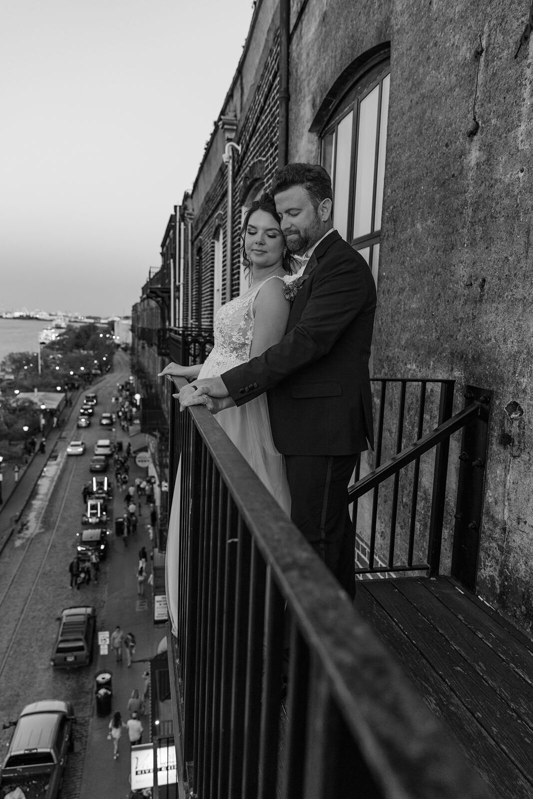 Groom with bride on balcony Vic's on the River Savannah Georgia