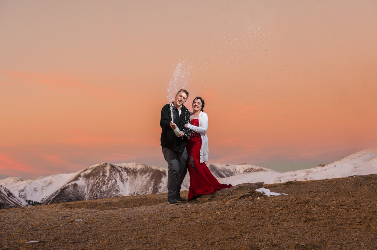 Excited engaged couple on Loveland Pass poppin' champagne to their engagement