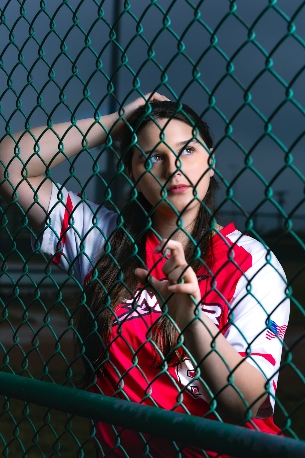 Lansing Michigan softball senior leaning against fence