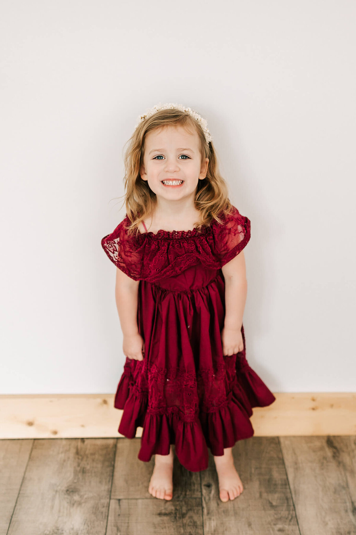 daughter smiling in red dress in family photography studio in Springfield MO