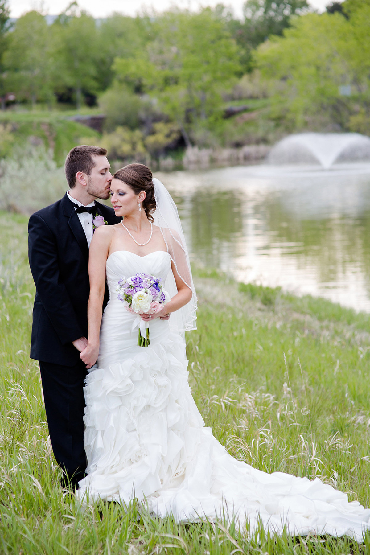 bride and groom in green field in denver