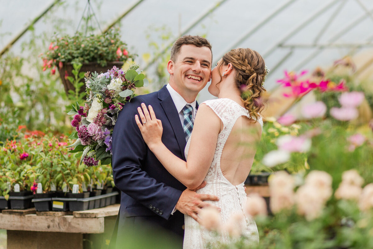 Bride-and-groom-kiss-inside-a-plant-filled-greenhouse-in-Monroe-WA-at-wedding-venue-Pine-Creek-Nursery-photo-by-Joanna-Monger-Photography