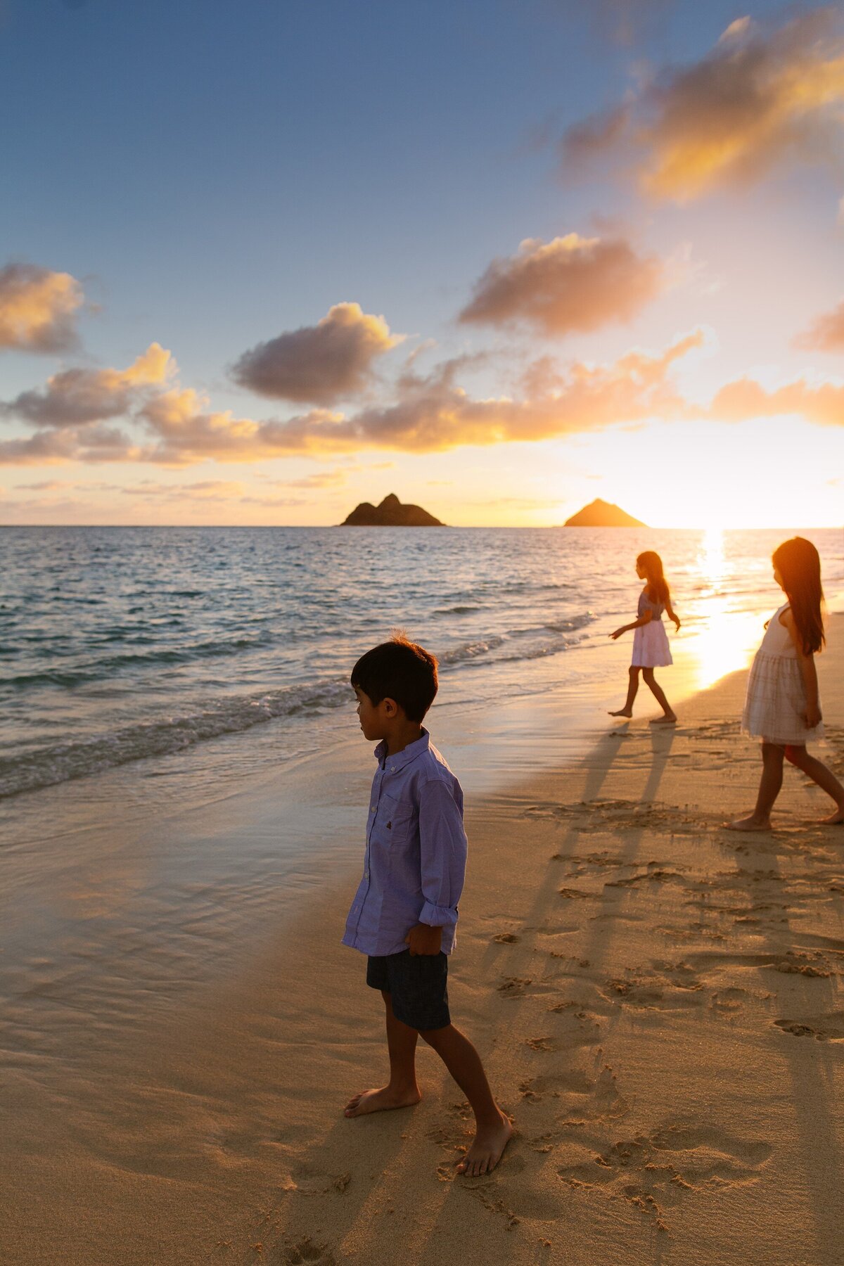siblings by the waters edge at sunrise over lanikai beach