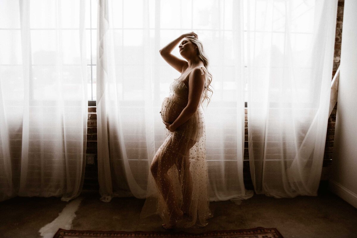 Maternity-indoor-session-portrait-studio-St-Louis-mom-playin-with-hair-in-free-people-golden-sequin-slip
