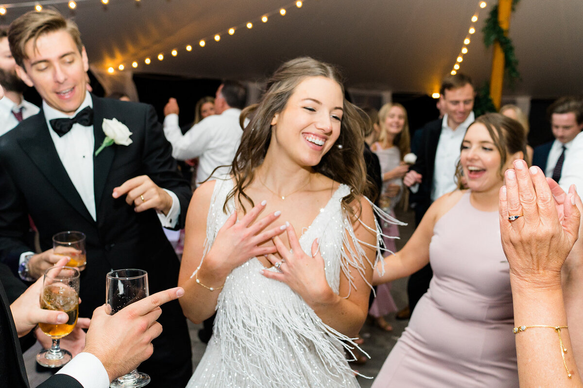 Bradley Estate bride changes into short fringe flapper dress and hits the dance floor. Sailcloth tent with string lights. Boston destination wedding.