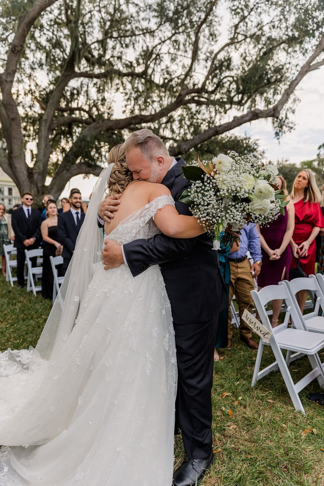 Father hugging daughter at wedding ceremony at Bella Cosa, Lake Wales, Florida
