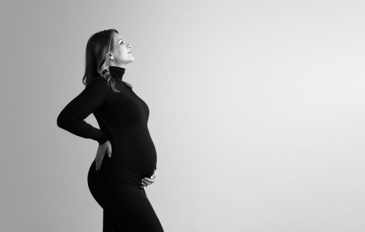 black and white silhouette of pregnant woman at maternity photoshoot