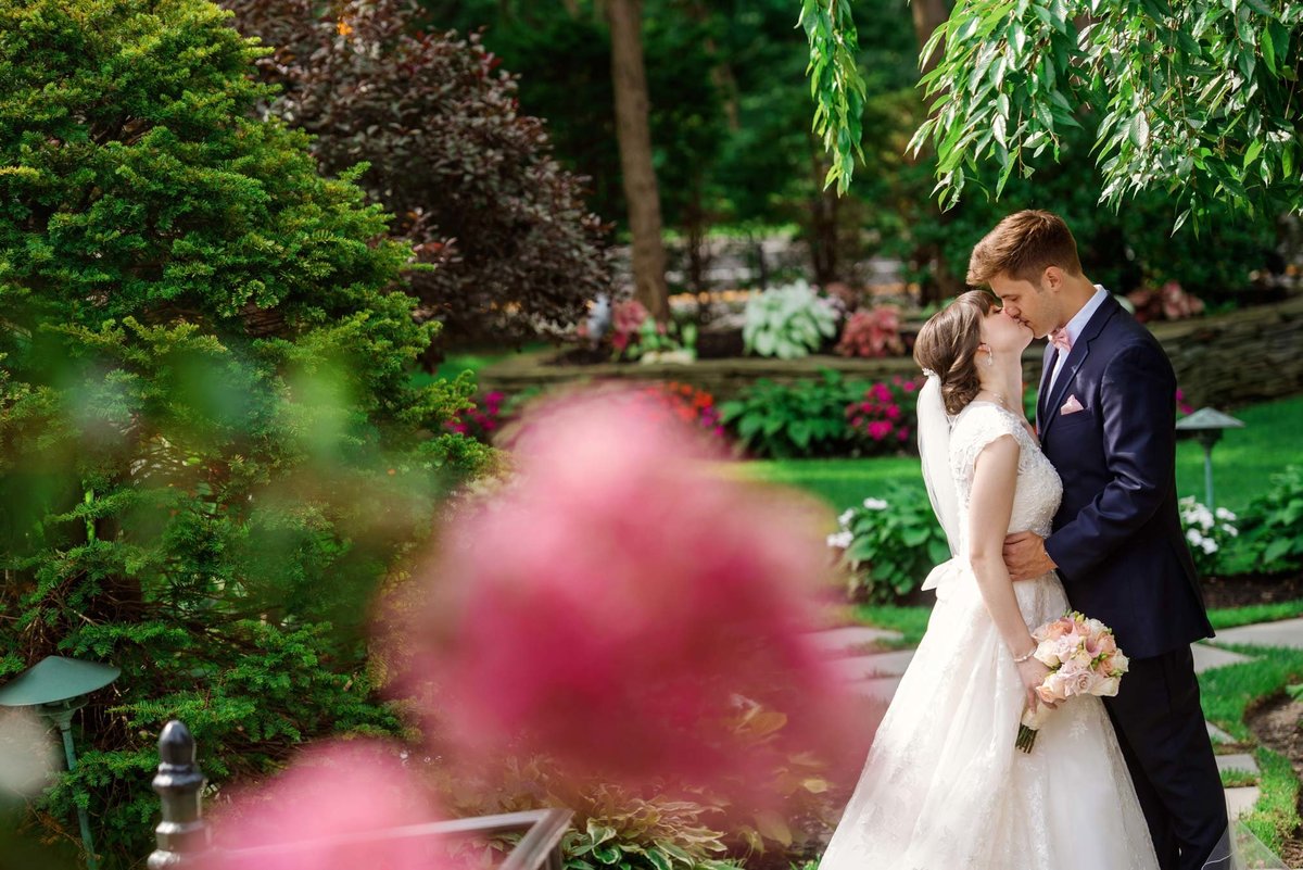 Bride and groom kissing at the gardens of Fox Hollow