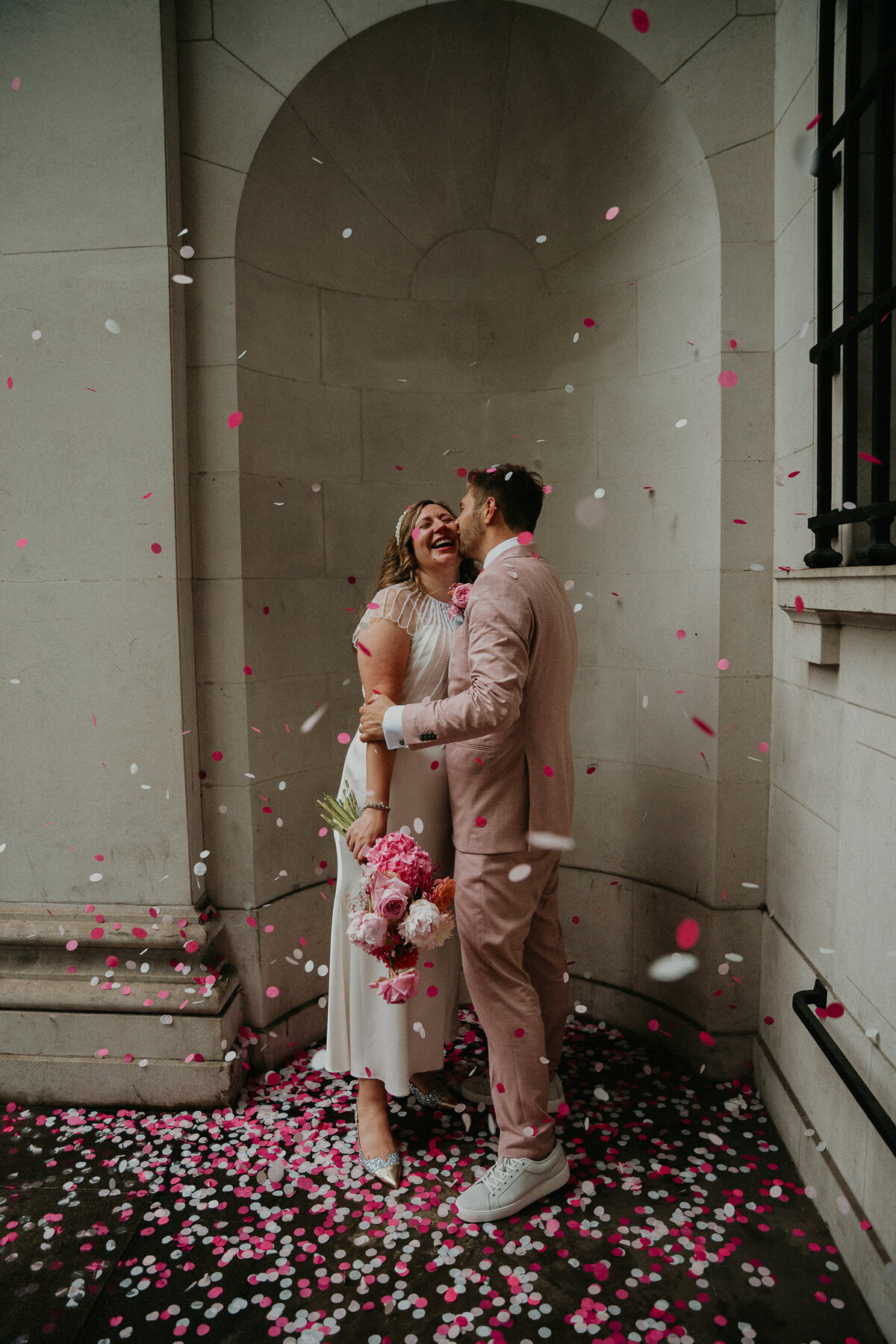 A bride and groom throw confetti at their wedding at Marylebone Town Hall in London. 