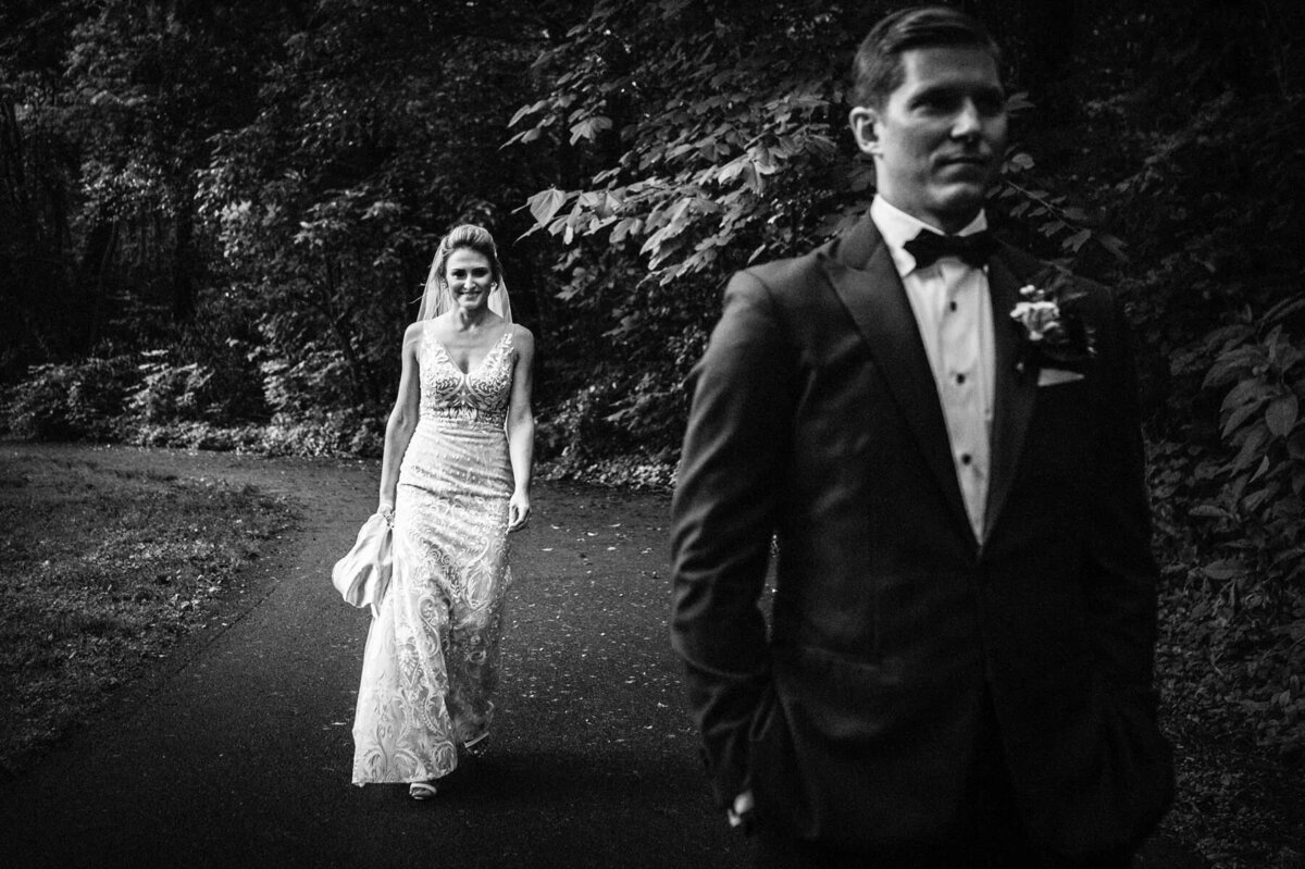 A bride walking up behind a groom.