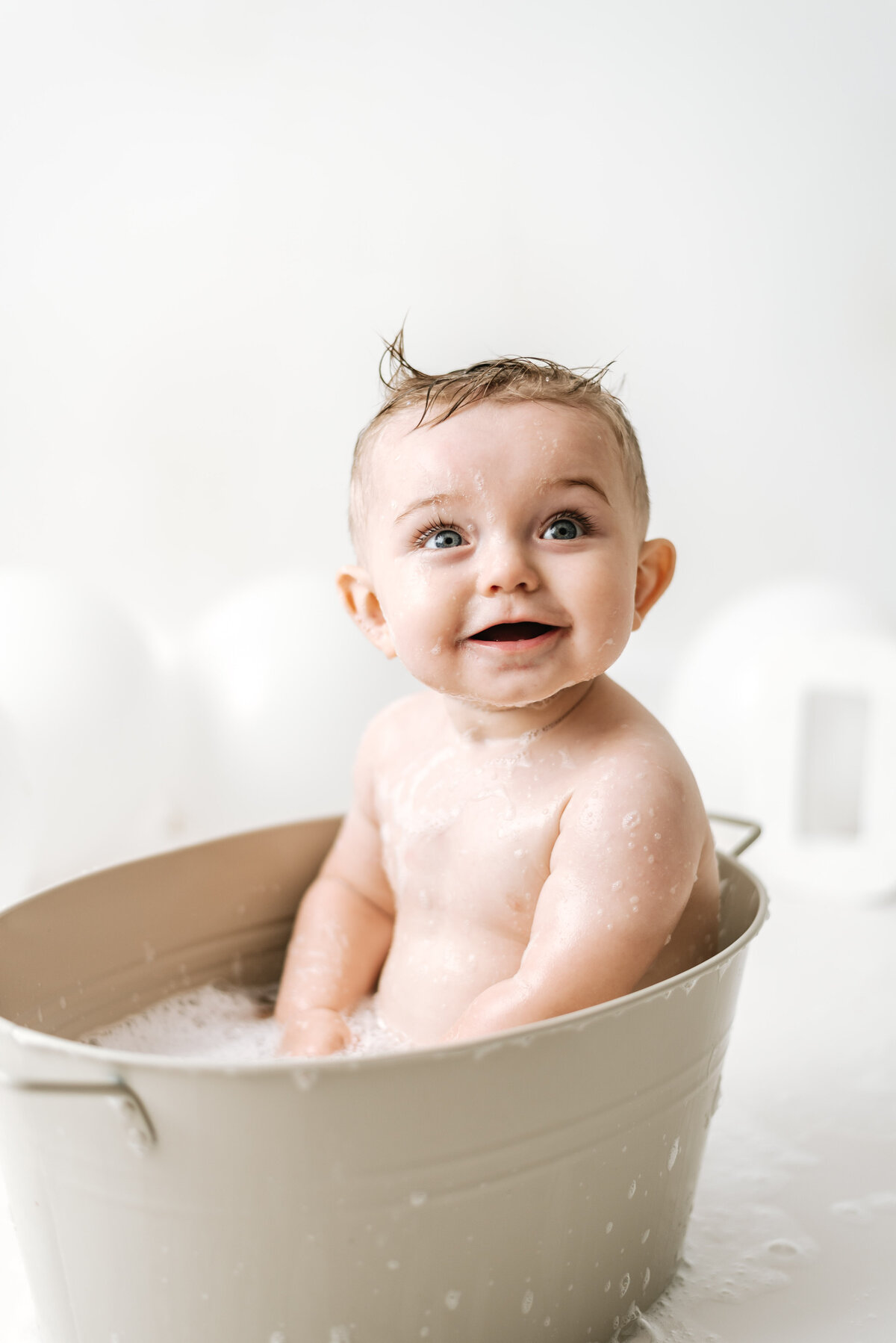 Baby boy in a bath at billingshurst cake smash photoshoot