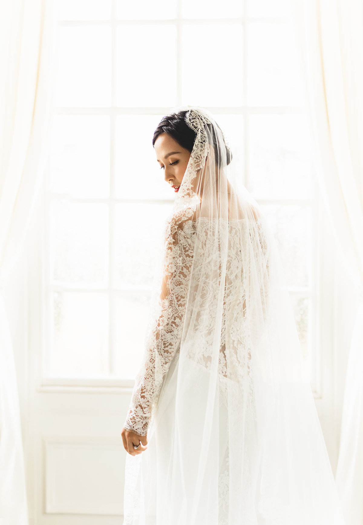 chinese bride in front of the window wearing a veil at hedsor house