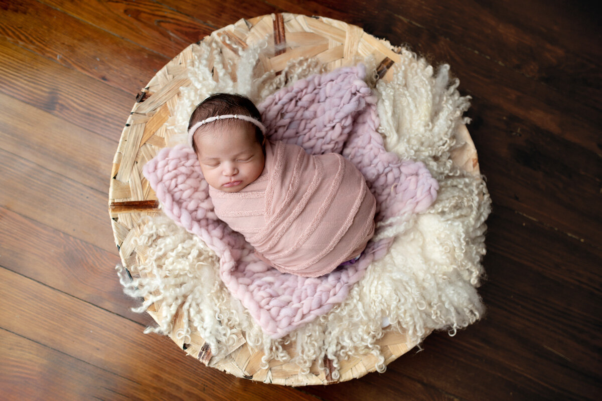 Newborn session of baby girl wearing a bow