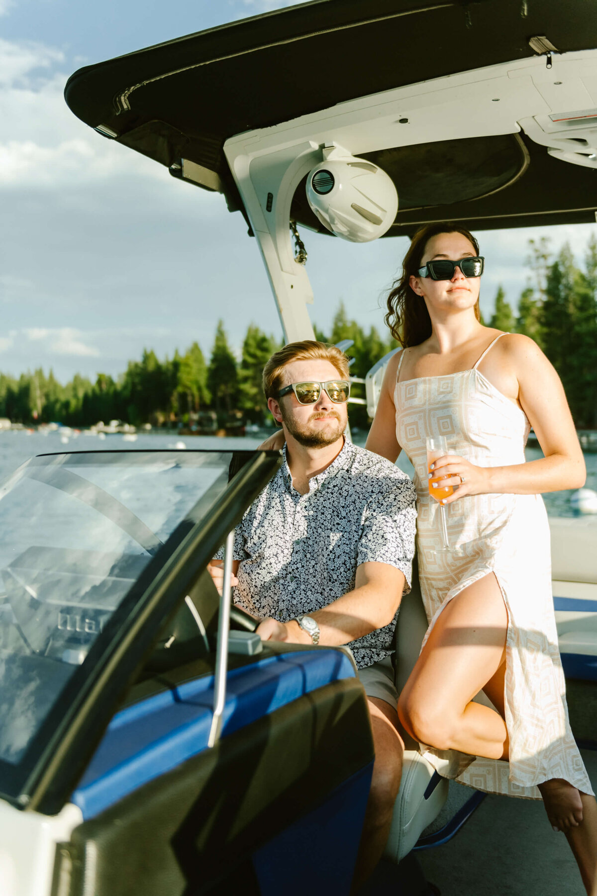 engaged couple in a boat and champagne in hand in Lake Tahoe