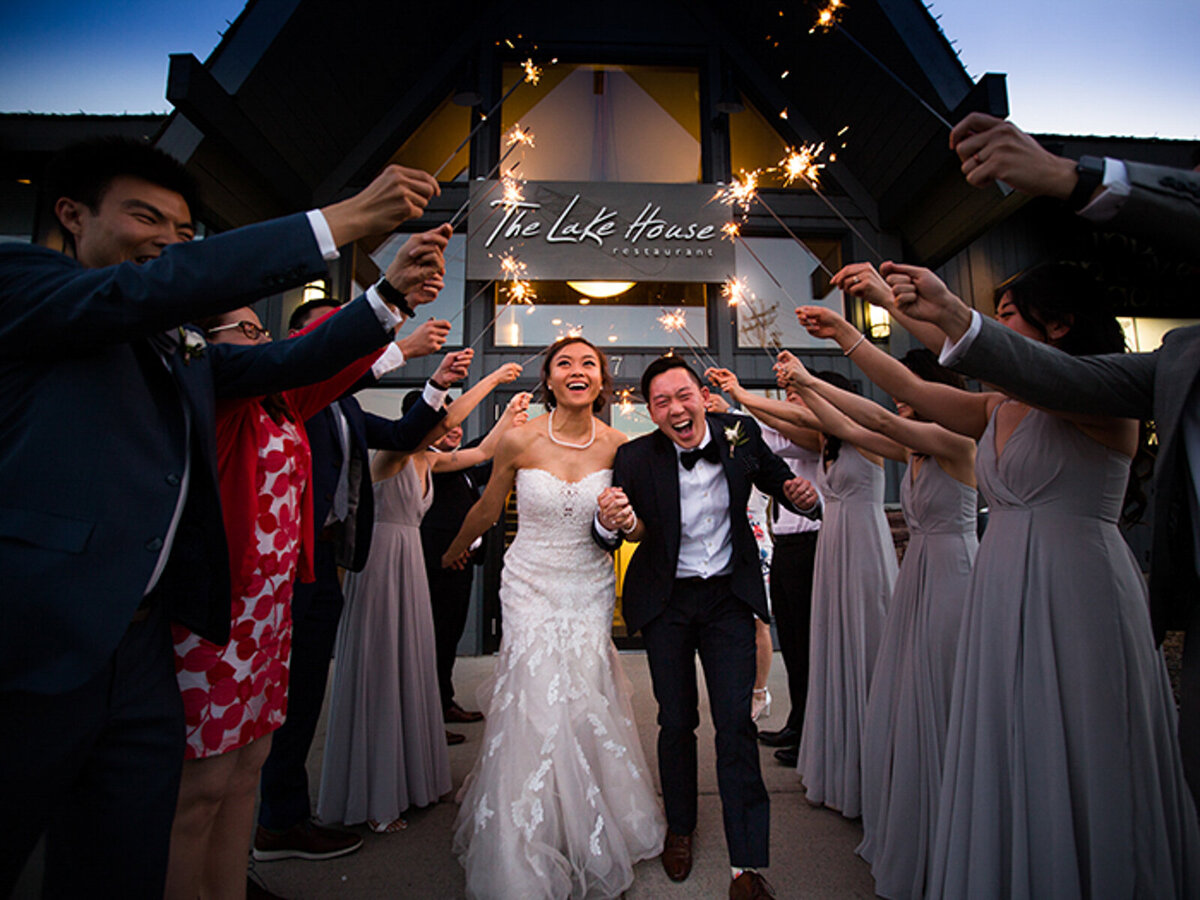 Couple exiting their reception with sparklers at The Lakehouse, a romantic sophisticated wedding venue in Calgary, featured on the Brontë Bride Vendor Guide.