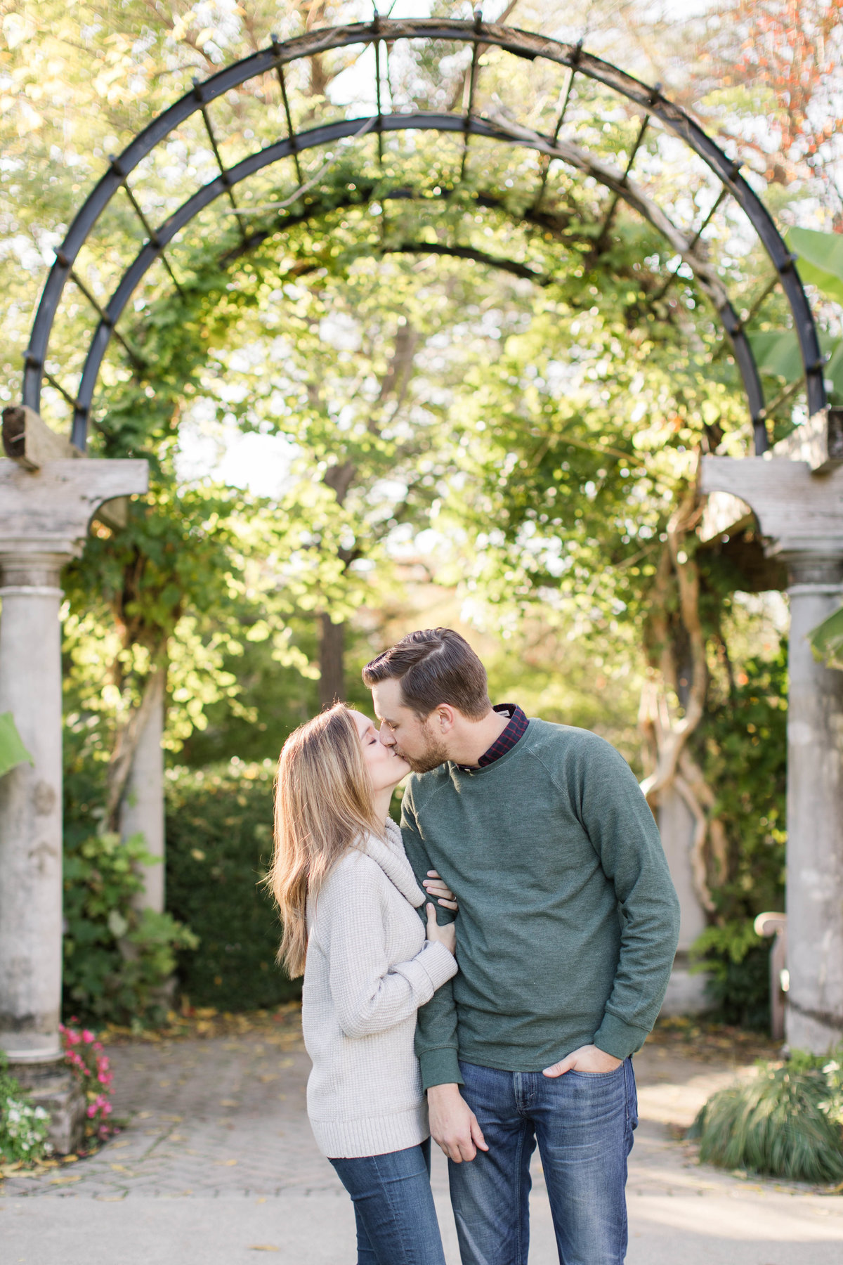 Ault Park Cincinnati family photos of mom and dad kissing sweetly in front of arch