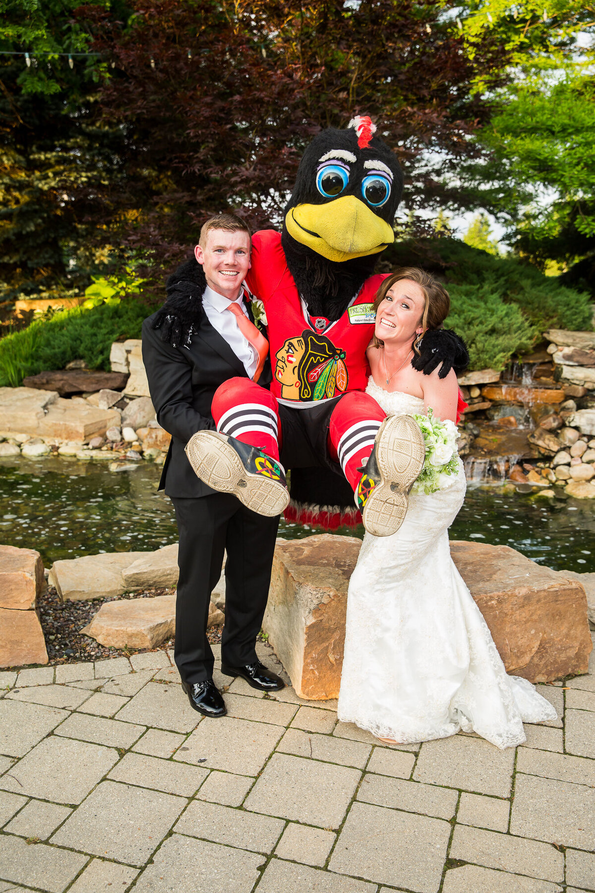 A fun bride and groom pose with the Tommy Hawk mascot from the Blackhawks