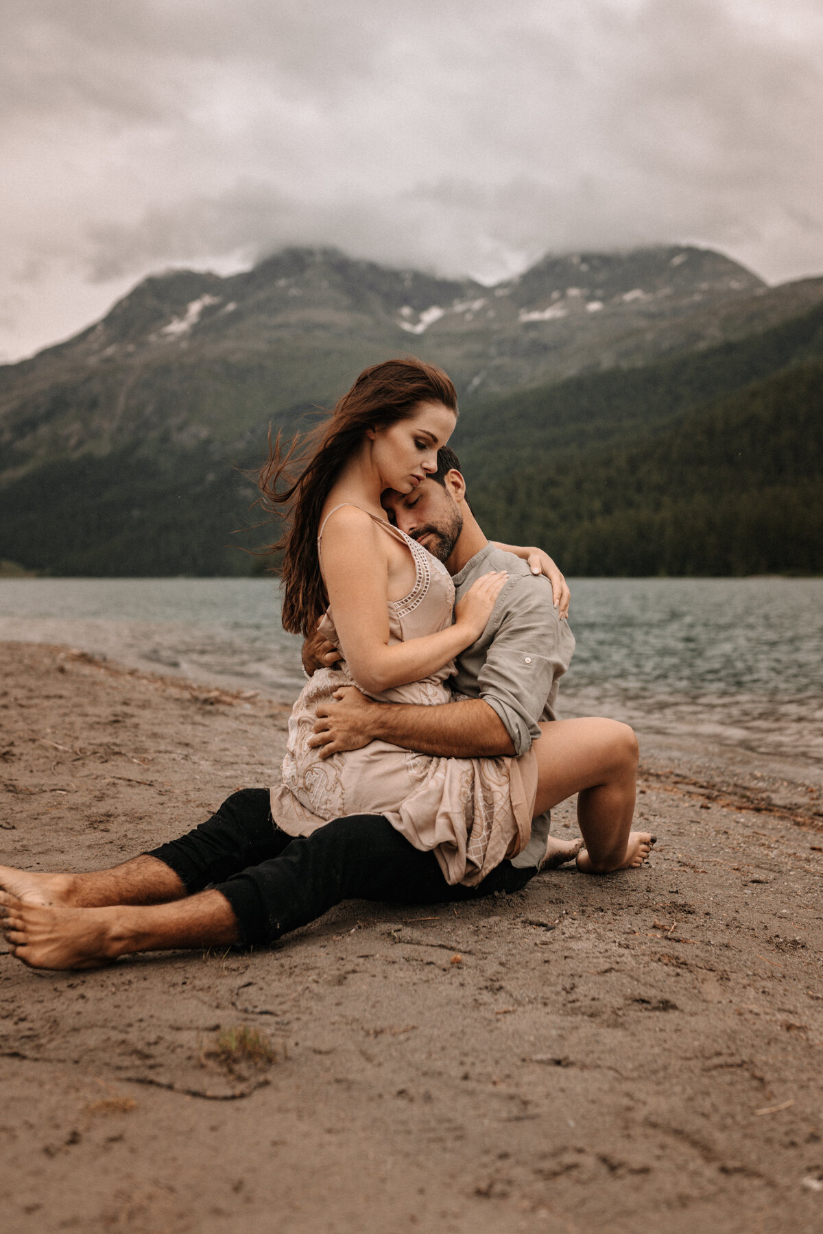 Liebespaar in inniger Pose sitzend an einem See in der Schweiz