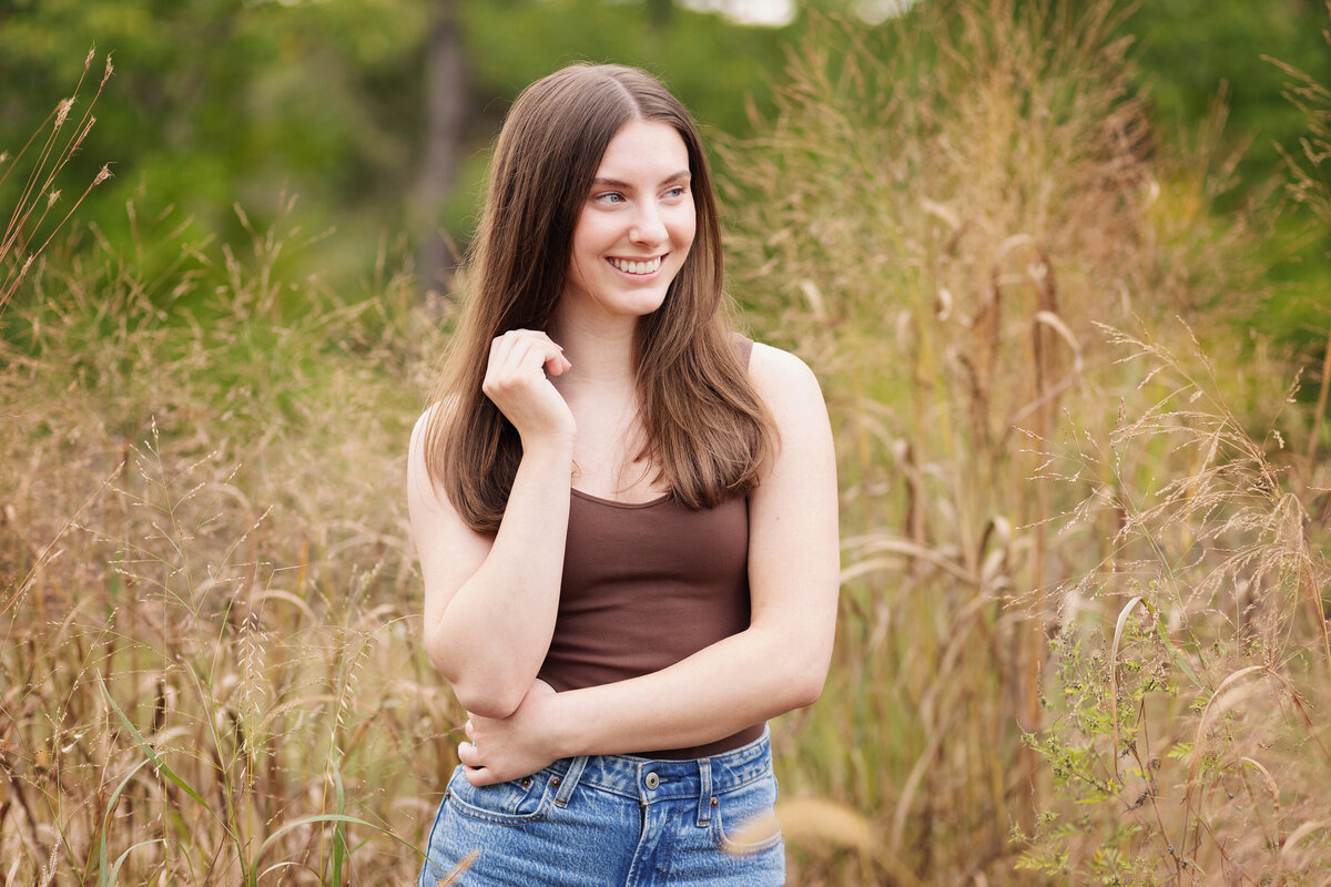 high school girl in tank top smiling in field