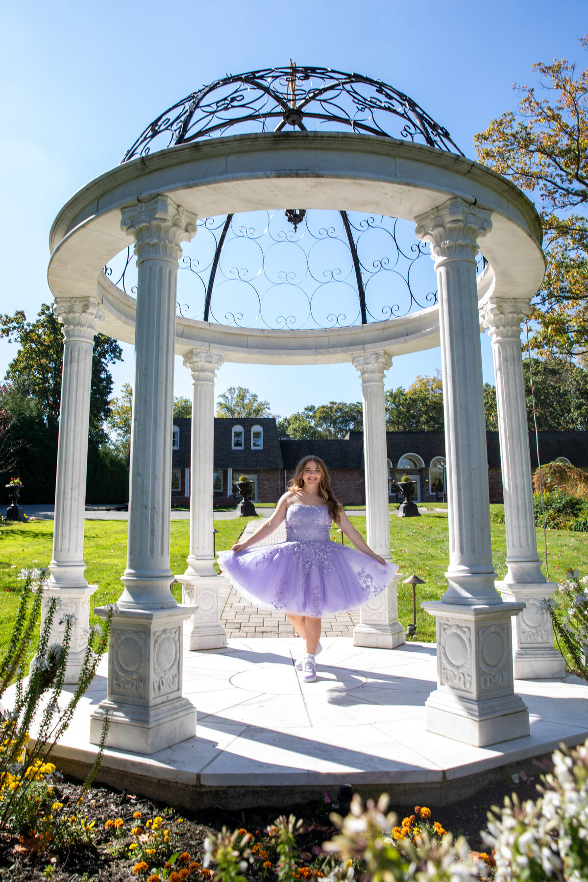 A teenage girl in a purple dress poses outside Old Tappan Manor bat mitzvah Bergen County bar photographer Milestone Images