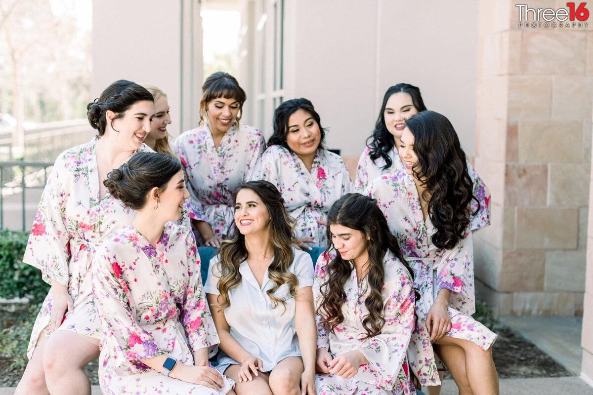 Bride and her bridesmaids hangout together in their robes prior to getting ready for the wedding ceremony