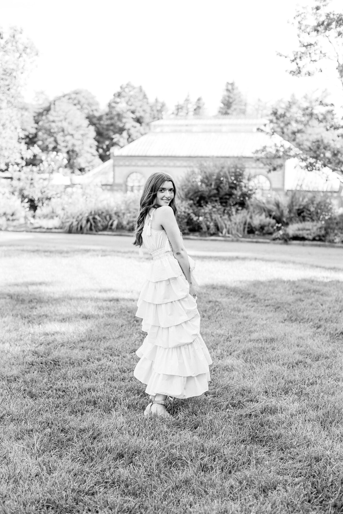 black and white photo of senior girl in front of conservatory at Biltmore Estate