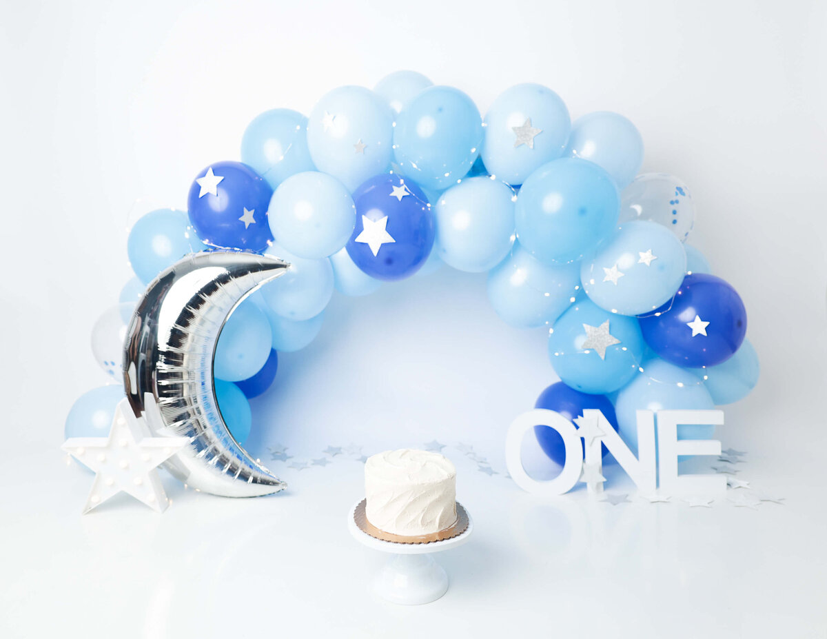A vibrant blue balloon-themed cake smash in Rochester, NY.