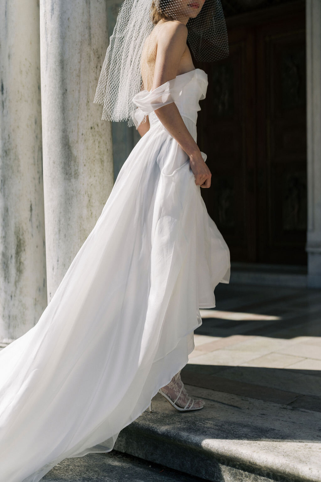 bride in wedding dress lifting skirt