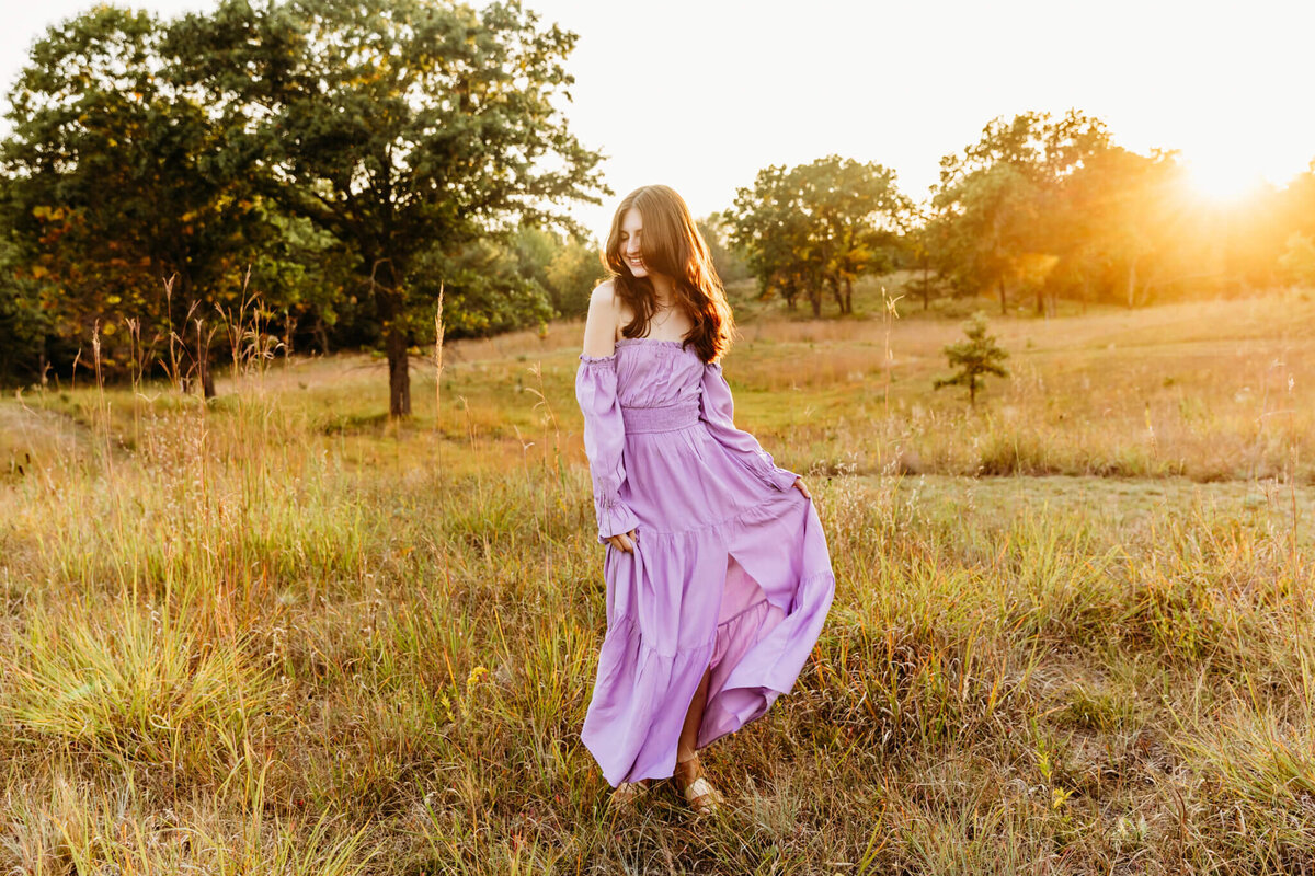 scenic view of a beautiful teen playing with her dress during her senior photography session