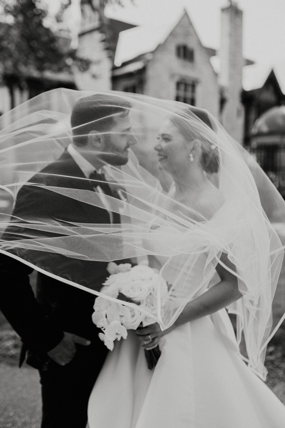 Candid wedding portrait of bride and groom and veil