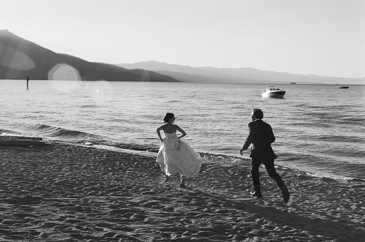 black and white film image couple running on beach south lake tahoe