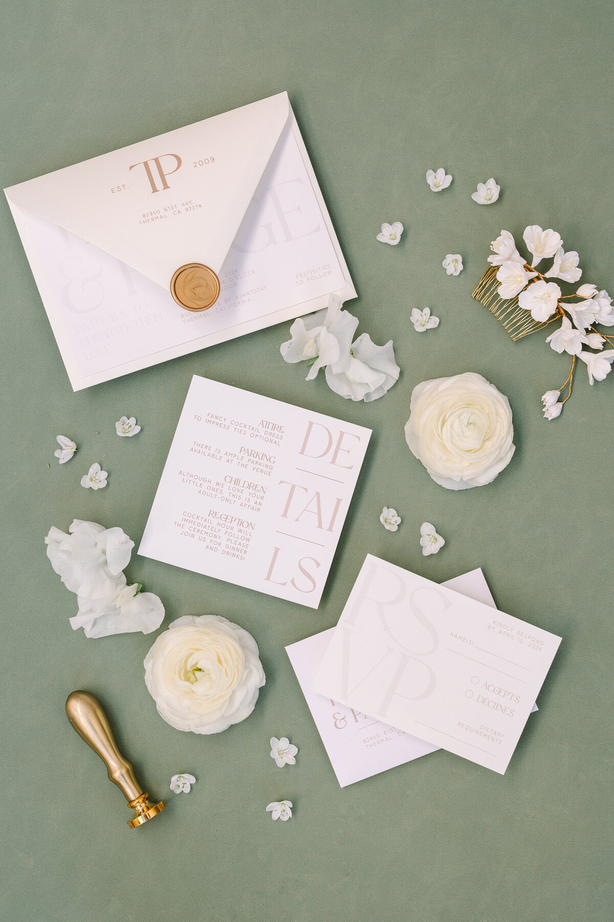 flat lay image of napa wedding invitation with sprinkled flowers and green background.