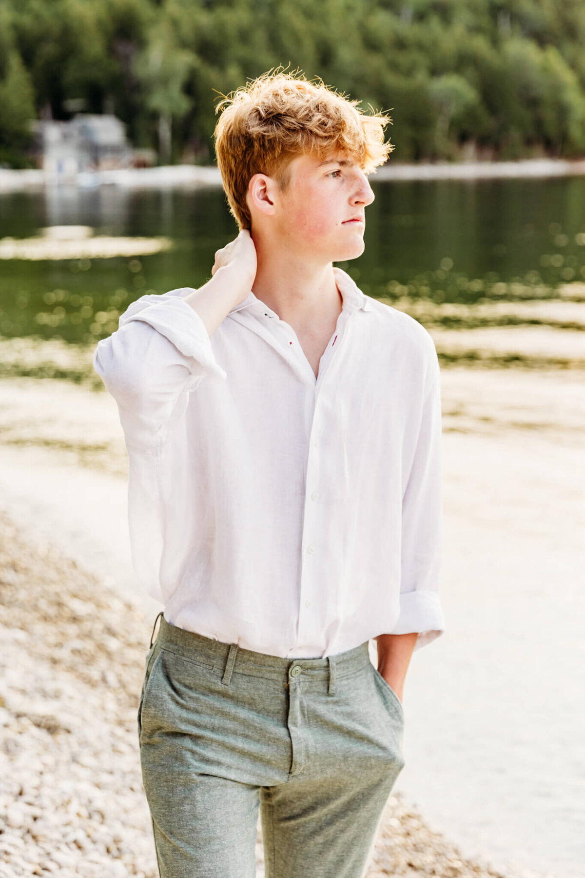 teenage boy rubbing his neck and looking into the water for senior photos