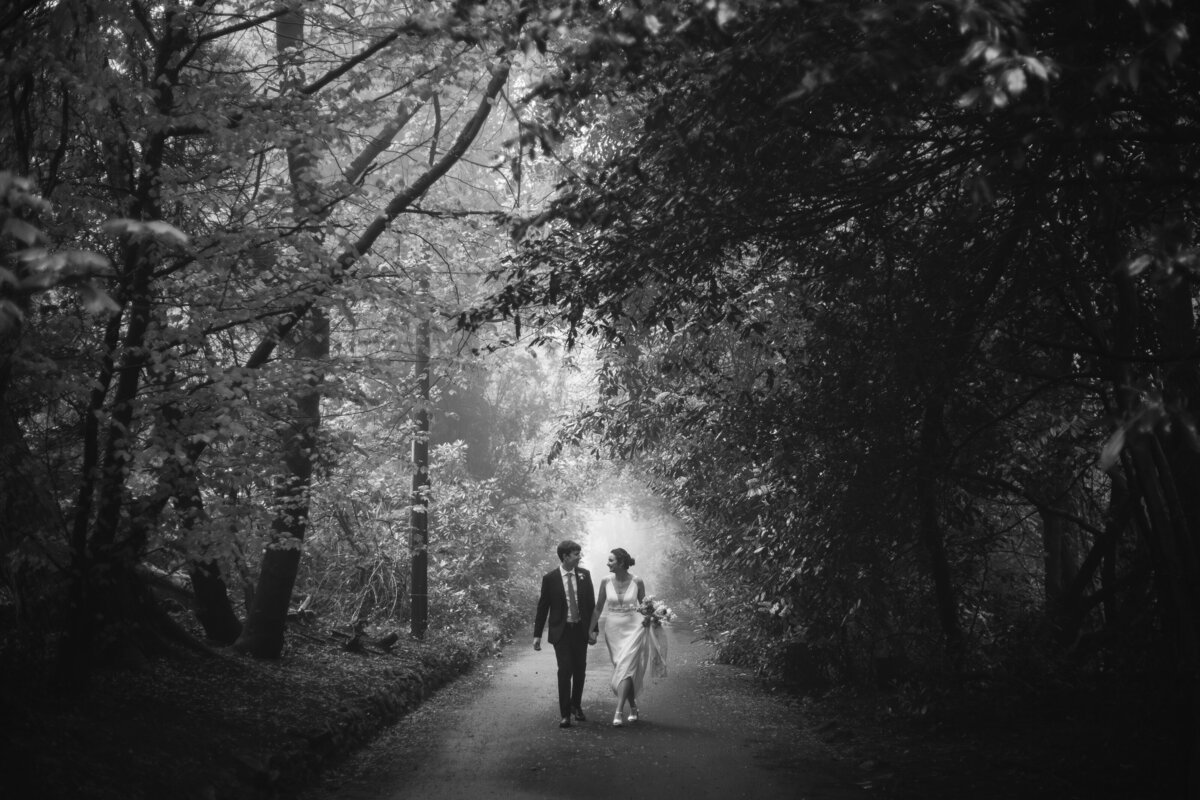 black and white photograph of bride and groom walking on thier wedding day