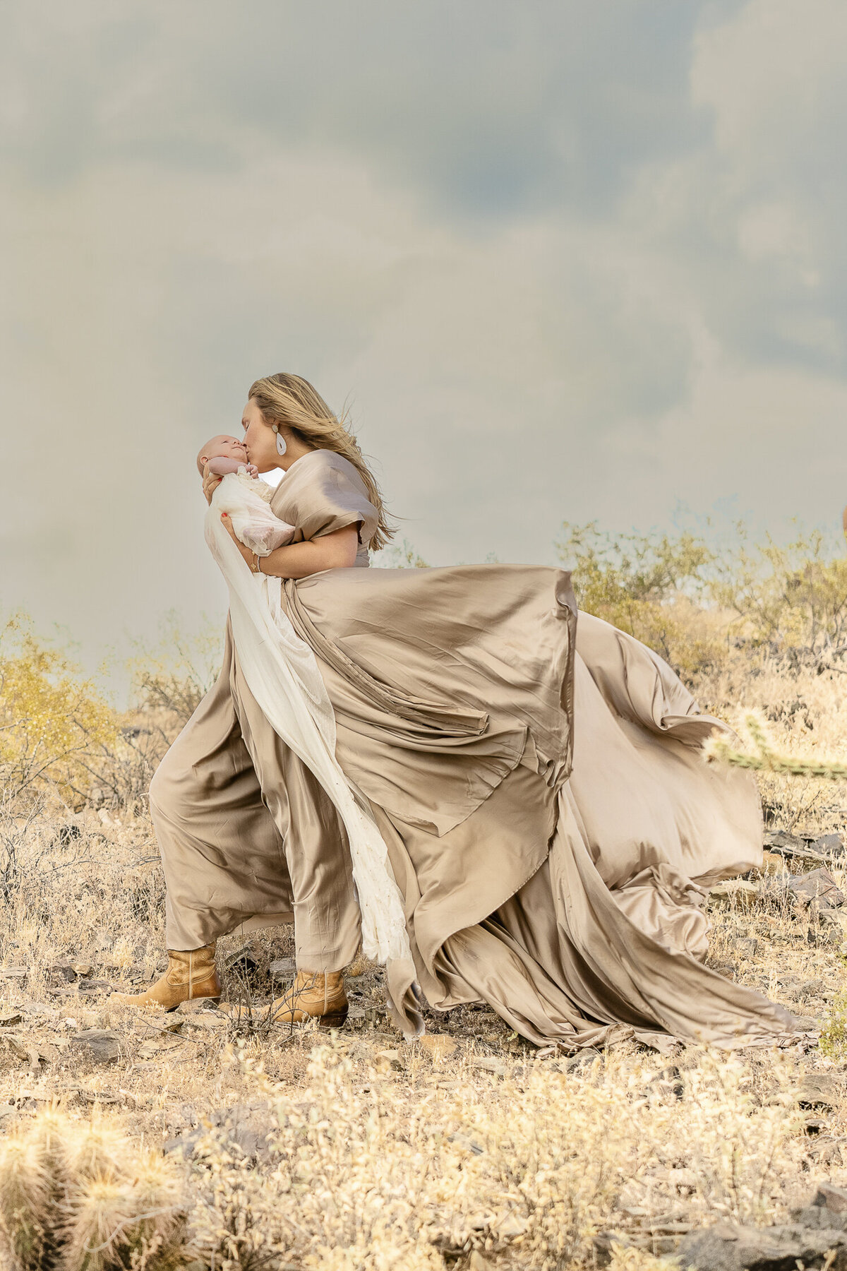 blonde Phoenix mother holding new born baby in the desert.