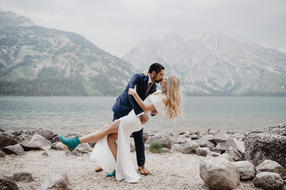 Photographers Jackson Hole capture bride and groom kissing at lake in Grand Teton National Park